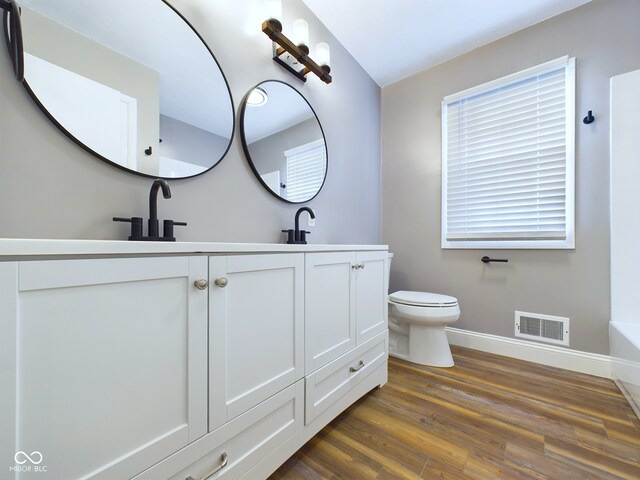 bathroom with vanity, hardwood / wood-style flooring, and toilet