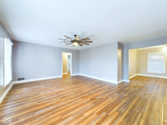 empty room with hardwood / wood-style floors and ceiling fan