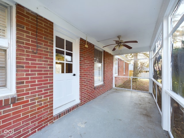 unfurnished sunroom featuring ceiling fan