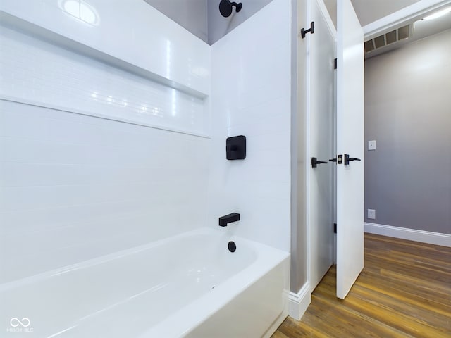 bathroom with bathing tub / shower combination and hardwood / wood-style flooring