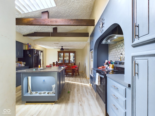 kitchen with ceiling fan, black fridge, light hardwood / wood-style floors, a textured ceiling, and stainless steel range with electric stovetop