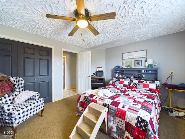 carpeted bedroom with a textured ceiling, a closet, and ceiling fan