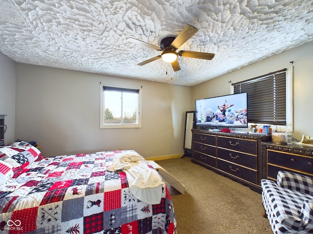 carpeted bedroom featuring ceiling fan and a textured ceiling