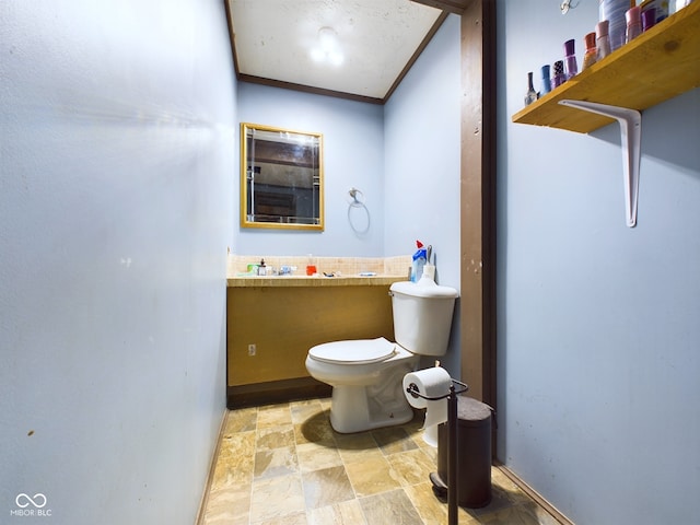 bathroom with crown molding and toilet