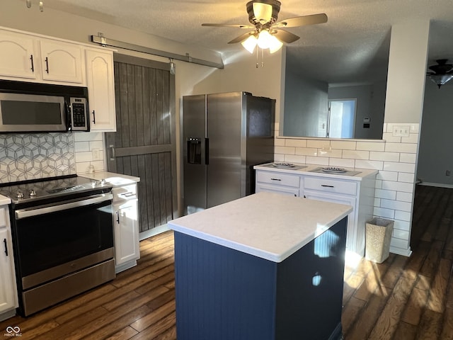 kitchen with white cabinets, ceiling fan, stainless steel appliances, and dark wood-type flooring