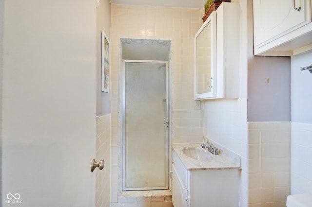 bathroom featuring vanity, a shower with door, toilet, and tile walls