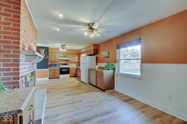 kitchen featuring ceiling fan, a textured ceiling, appliances with stainless steel finishes, and light hardwood / wood-style flooring