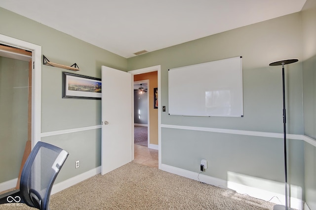 unfurnished office featuring light carpet and ceiling fan