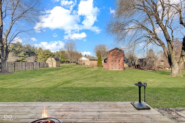 view of yard featuring a wooden deck and a storage unit