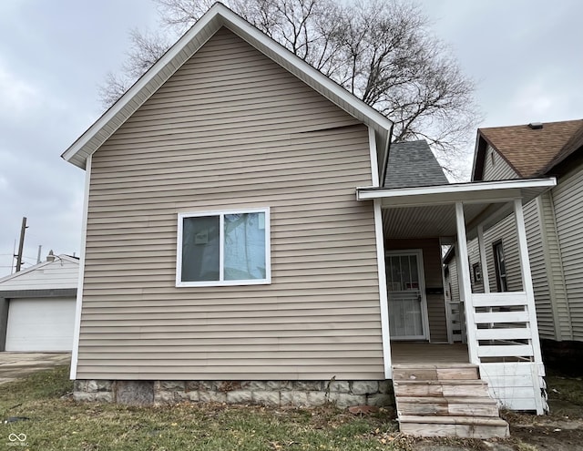 view of side of home featuring covered porch and an outdoor structure