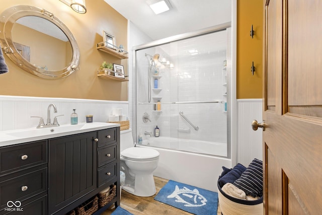 full bathroom featuring hardwood / wood-style floors, vanity, enclosed tub / shower combo, and toilet