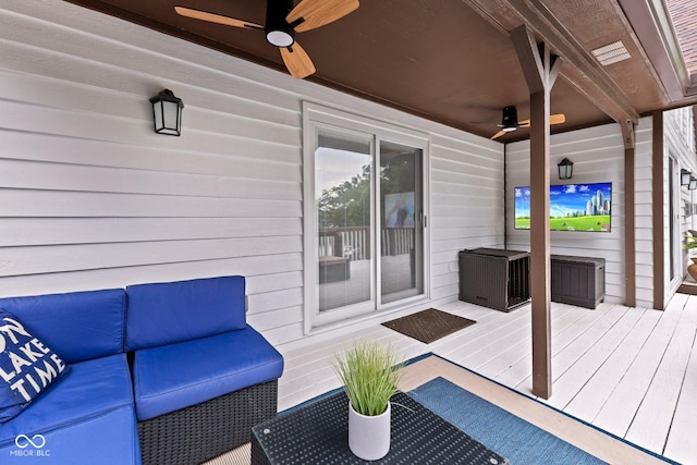 wooden deck with an outdoor living space and ceiling fan