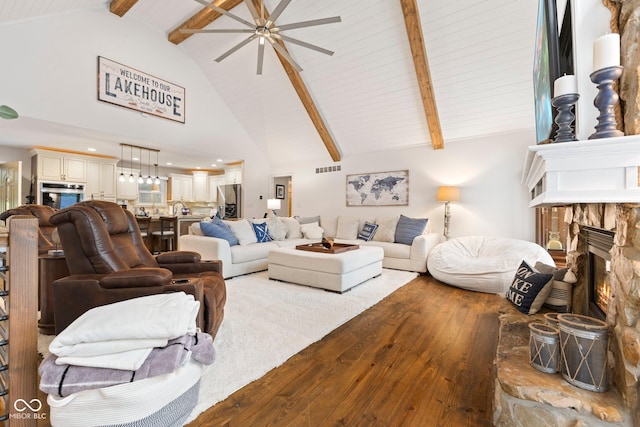 living room with hardwood / wood-style flooring, a fireplace, high vaulted ceiling, and beamed ceiling