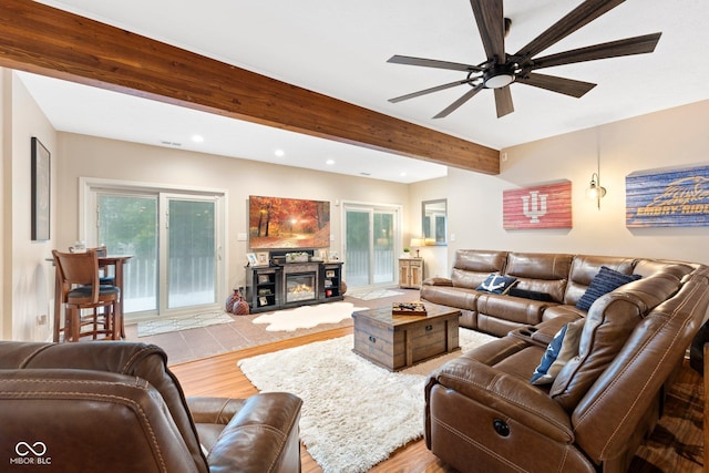 living room featuring hardwood / wood-style floors, ceiling fan, and beam ceiling