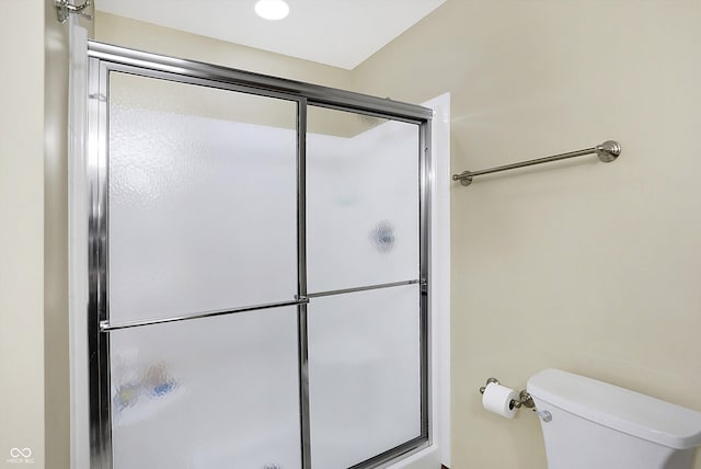 bathroom with an enclosed shower and toilet