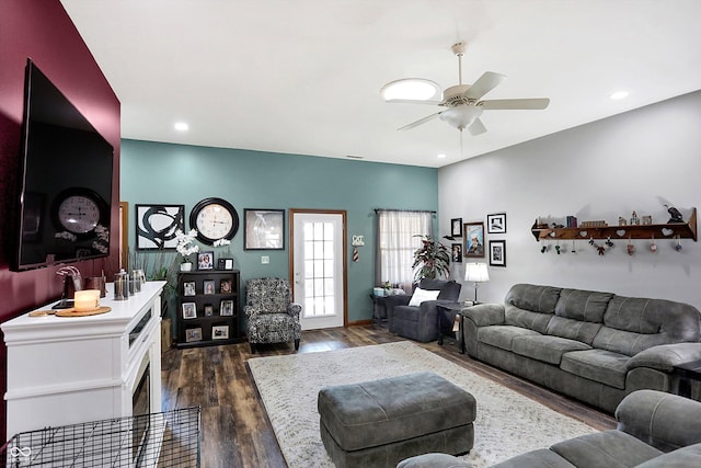 living room featuring ceiling fan and dark hardwood / wood-style flooring