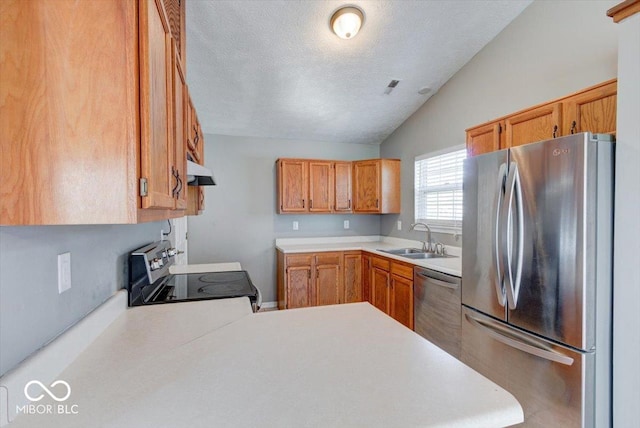 kitchen featuring lofted ceiling, sink, a textured ceiling, kitchen peninsula, and stainless steel appliances