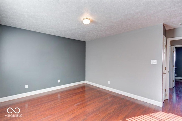 unfurnished room with a textured ceiling and hardwood / wood-style flooring