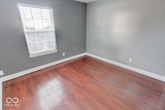 unfurnished room with dark hardwood / wood-style flooring