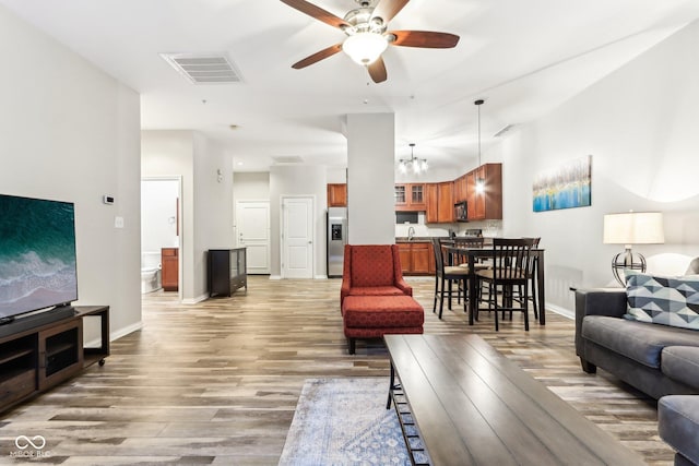 living room with hardwood / wood-style floors, ceiling fan, and sink