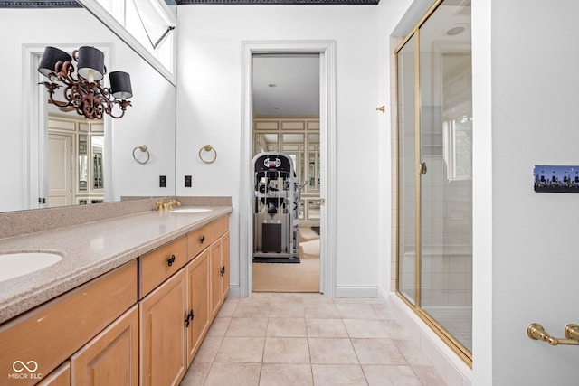 bathroom with tile patterned floors, vanity, a shower with shower door, and an inviting chandelier