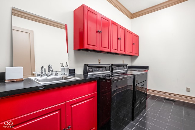 clothes washing area featuring cabinets, crown molding, sink, washer and dryer, and dark tile patterned flooring