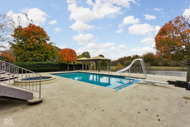 view of swimming pool with a patio, an in ground hot tub, and a water slide