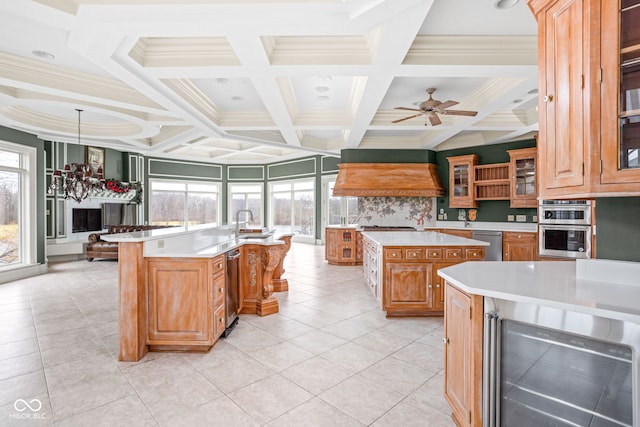 kitchen with backsplash, coffered ceiling, beverage cooler, pendant lighting, and a center island