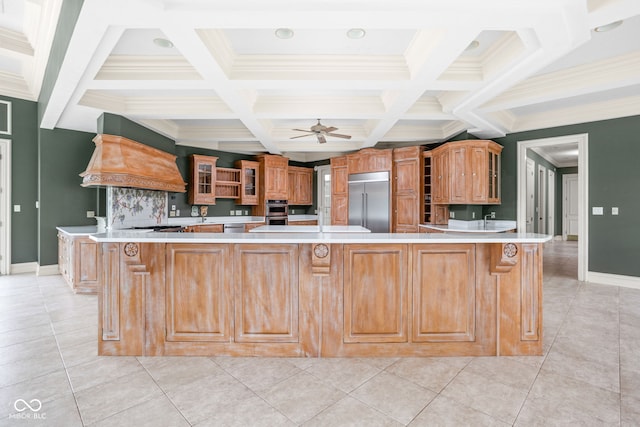 kitchen featuring built in fridge, a large island, light tile patterned floors, and premium range hood