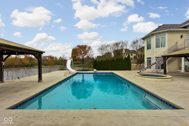 view of swimming pool with a gazebo, a patio area, an in ground hot tub, and a water slide