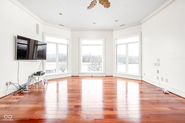 unfurnished living room with wood-type flooring and ornamental molding