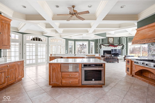 kitchen with french doors, stainless steel oven, a center island, coffered ceiling, and beamed ceiling