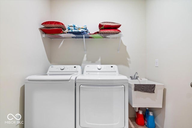 washroom with washing machine and dryer and sink