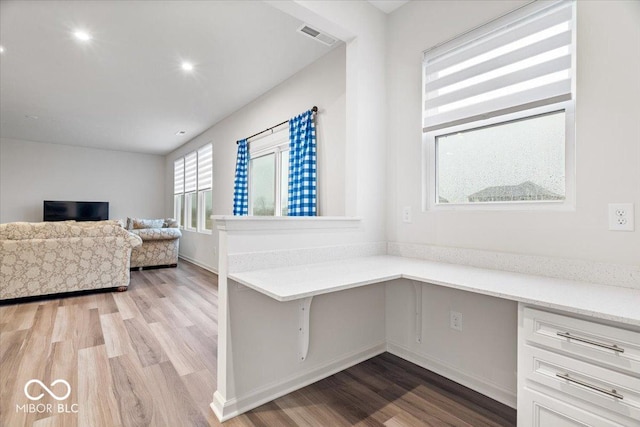 office featuring light hardwood / wood-style floors and built in desk