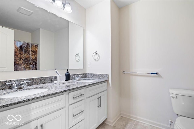 bathroom with tile patterned floors, vanity, and toilet