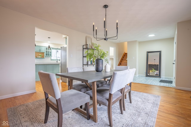 dining space with a notable chandelier, light hardwood / wood-style floors, plenty of natural light, and sink