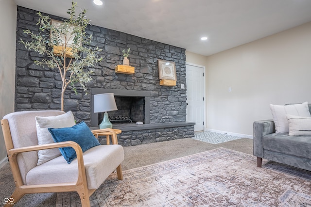 living room with carpet and a stone fireplace