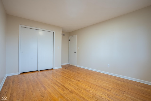 unfurnished bedroom with a closet and light hardwood / wood-style flooring