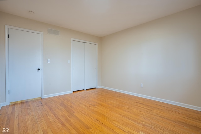 unfurnished bedroom with a closet and light hardwood / wood-style floors