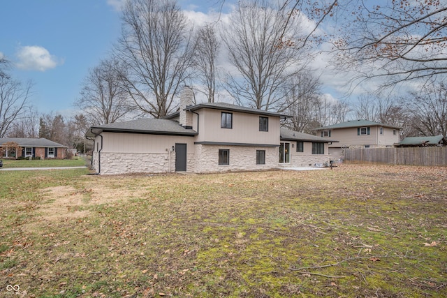 rear view of property with a yard