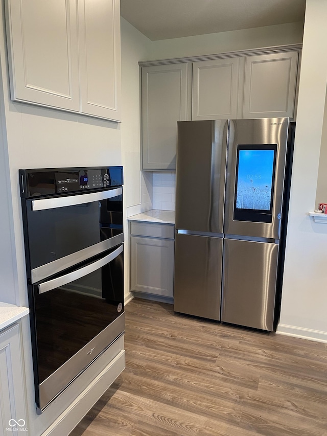 kitchen featuring stainless steel appliances, gray cabinets, and light hardwood / wood-style floors