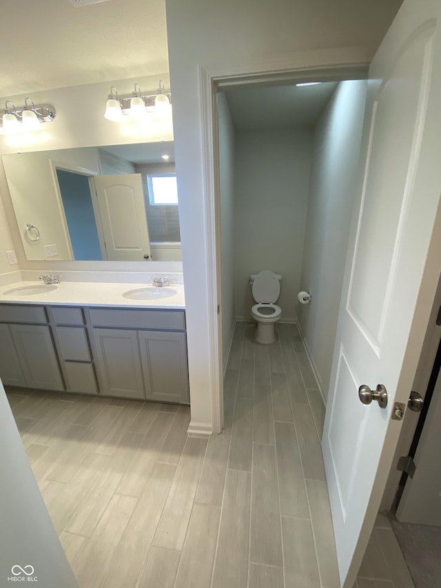 bathroom with toilet, vanity, and hardwood / wood-style flooring