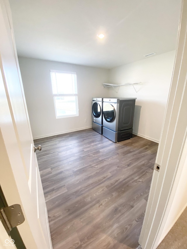 washroom with dark hardwood / wood-style floors and washer and clothes dryer