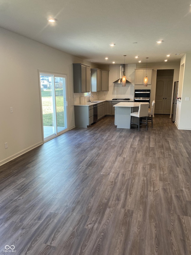 kitchen with pendant lighting, gray cabinetry, a center island, sink, and dark hardwood / wood-style flooring