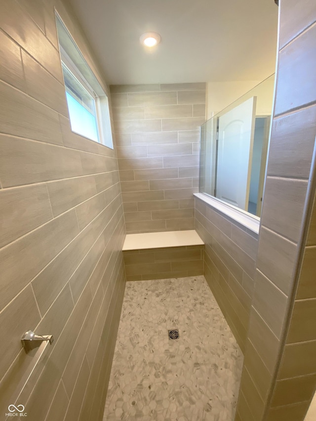 bathroom featuring tile walls and walk in shower