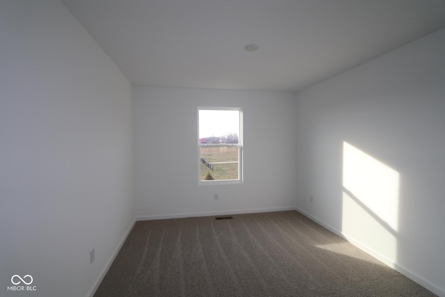 unfurnished room featuring dark carpet