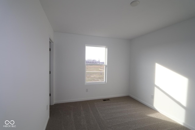 unfurnished room with dark carpet