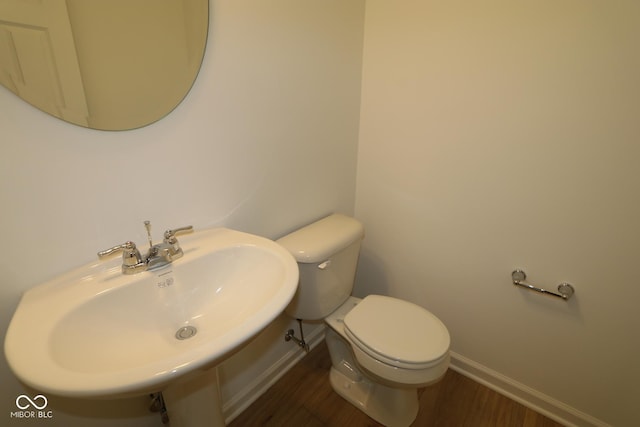 bathroom featuring toilet, sink, and hardwood / wood-style floors