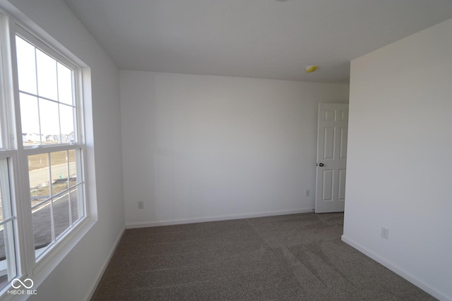 empty room featuring dark colored carpet