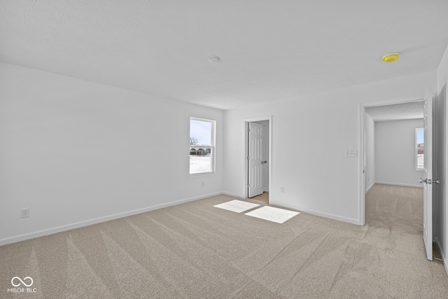 unfurnished bedroom with baseboards and light colored carpet